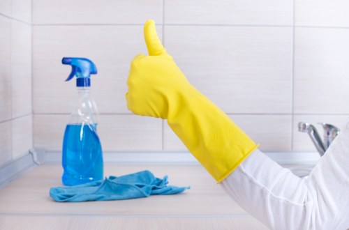 Cleaner working on glass panels for a business property in Merton